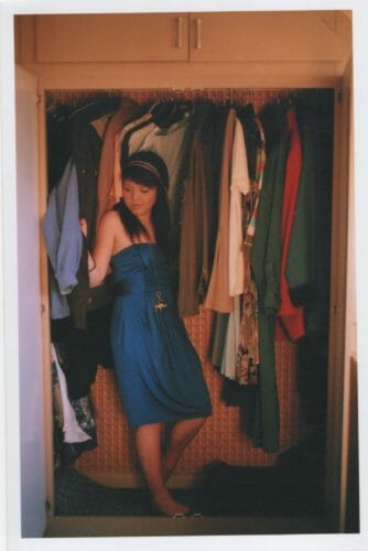 colour film portrait of girl in clothing closet