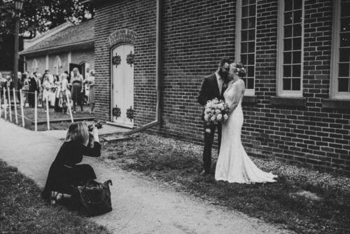 chelsey cunningham photographing bride and groom in front of enoch turner schoolhouse