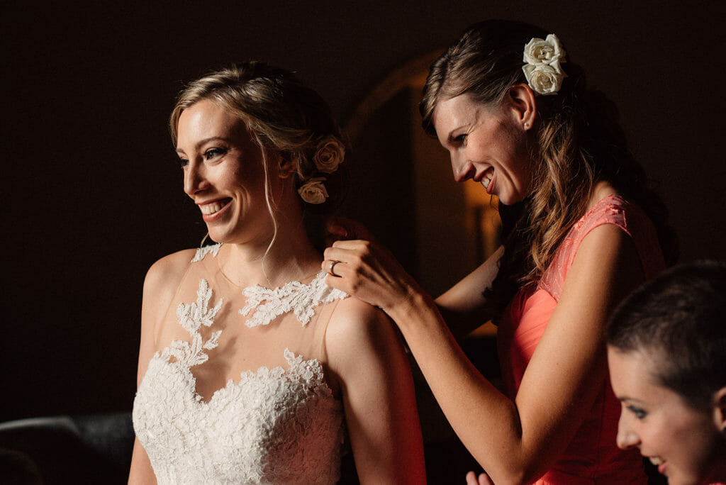 a natural moment between bride and sister while getting ready