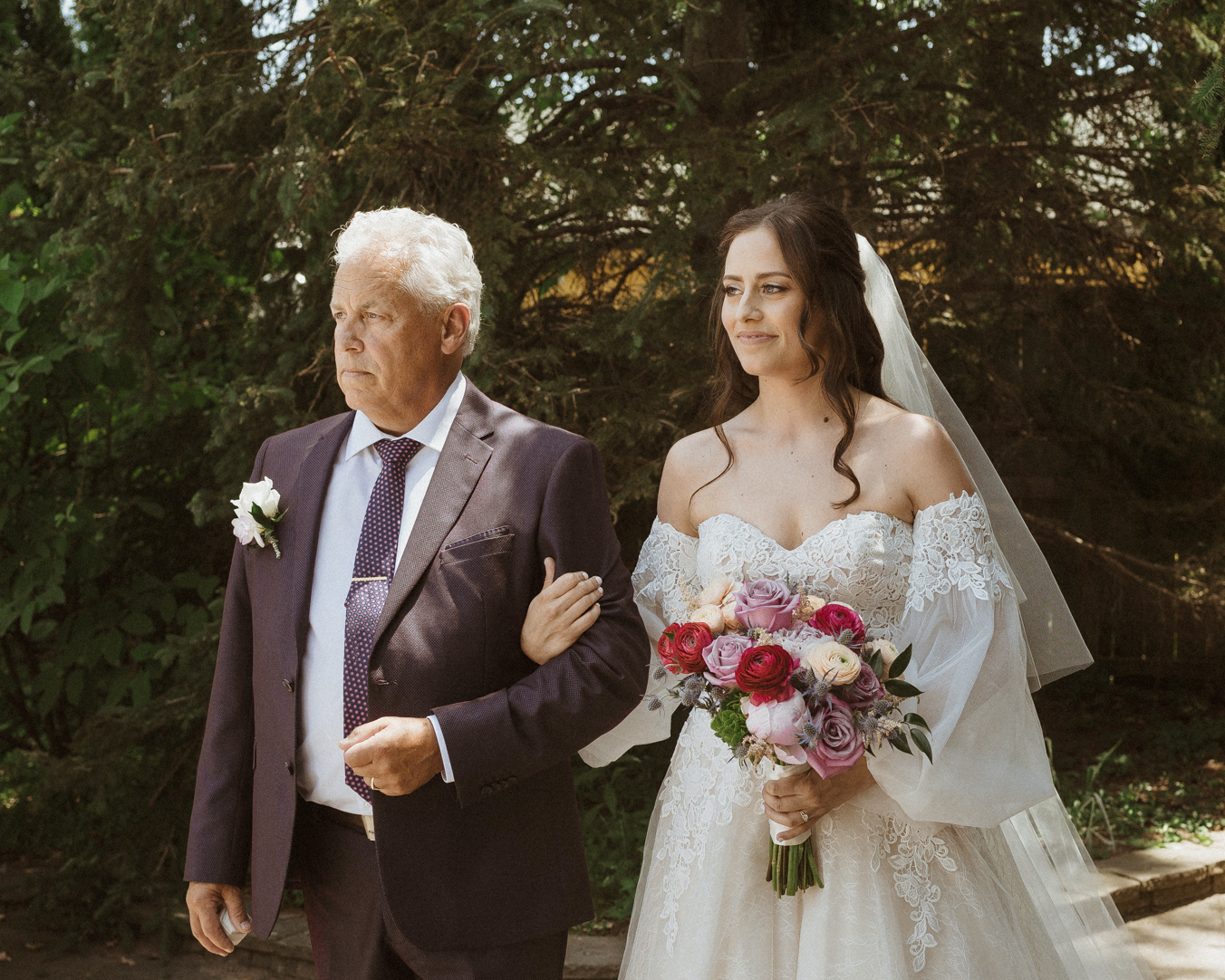 bride stands at the top of wedding ceremony aisle with father